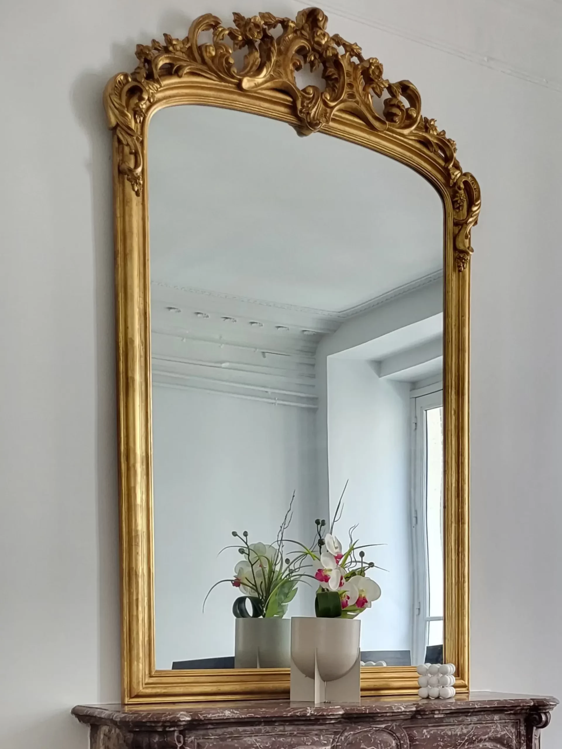 Cheminée ancienne en marbre avec un grand miroir ancien sculpté et doré.