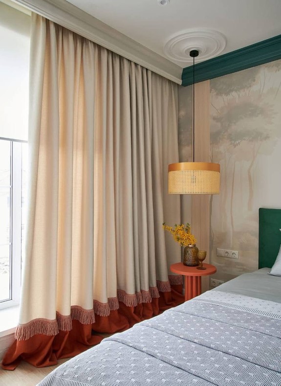 Rideaux bicolores, deux couleurs séparées par une passementerie rouille dans une chambre élégante, détail couture sur textile.
