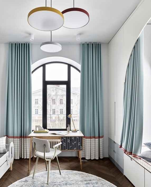 Rideaux bicolores bleu en haut et blanc en bas avec un galon décoratif rouge. Décoration affirmée.
